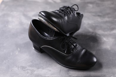 Photo of Pair of shoes for tap dance on grey surface, closeup