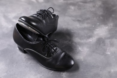 Photo of Pair of shoes for tap dance on grey surface, closeup. Space for text