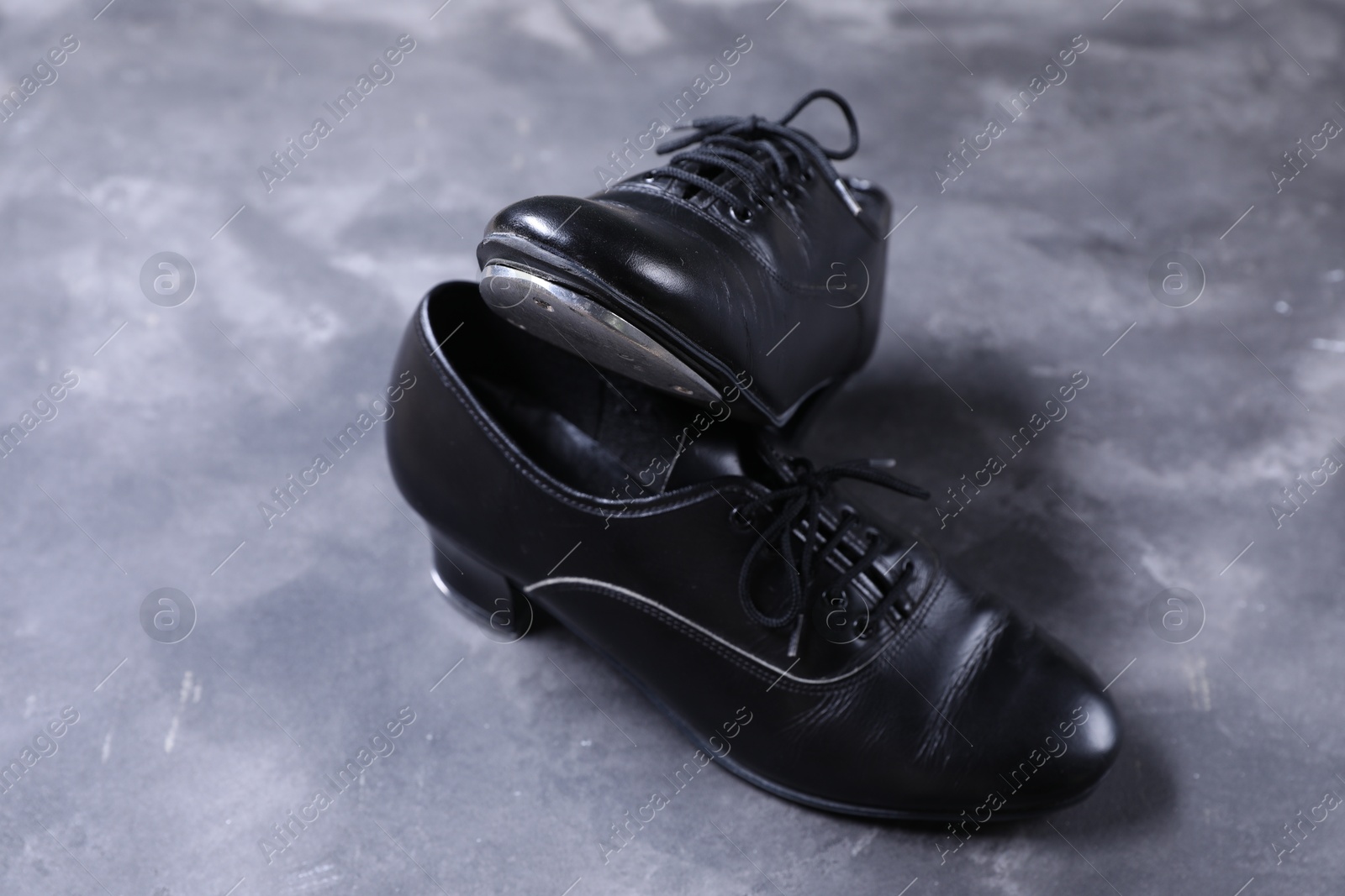 Photo of Pair of shoes for tap dance on grey surface, closeup