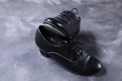 Photo of Pair of shoes for tap dance on grey surface, closeup
