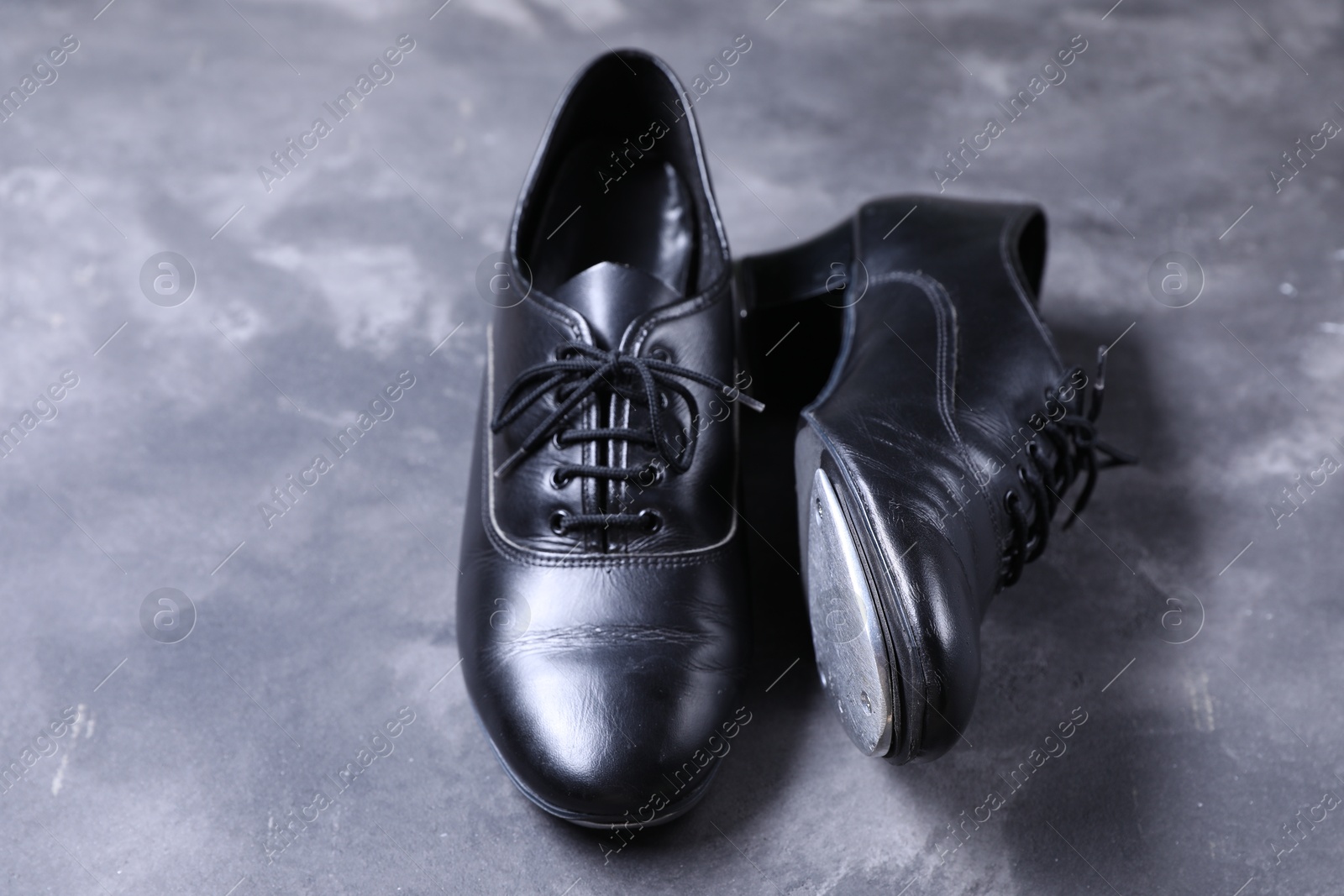 Photo of Pair of shoes for tap dance on grey surface, closeup