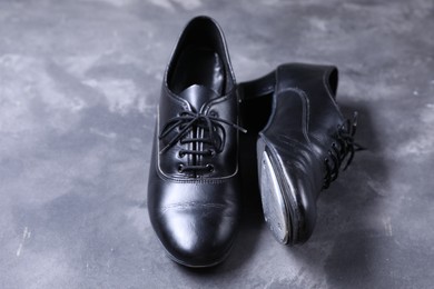 Photo of Pair of shoes for tap dance on grey surface, closeup