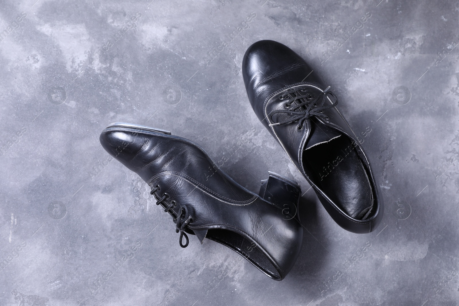 Photo of Pair of tap shoes on grey surface, top view. Tap dance