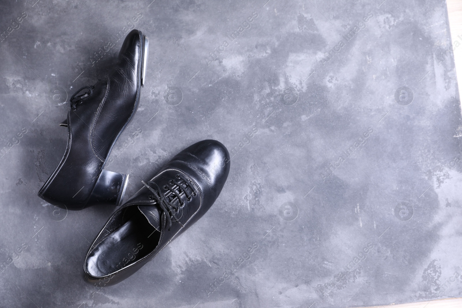 Photo of Pair of shoes for tap dance on grey surface, top view. Space for text
