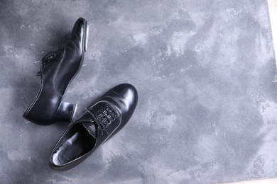 Photo of Pair of shoes for tap dance on grey surface, top view. Space for text