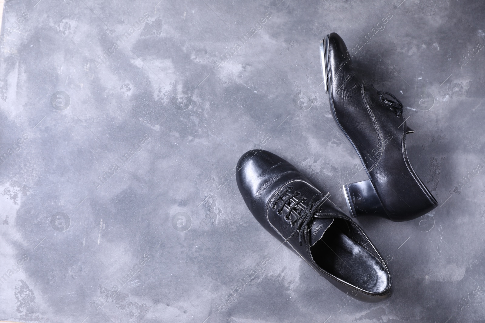 Photo of Pair of shoes for tap dance on grey surface, top view. Space for text