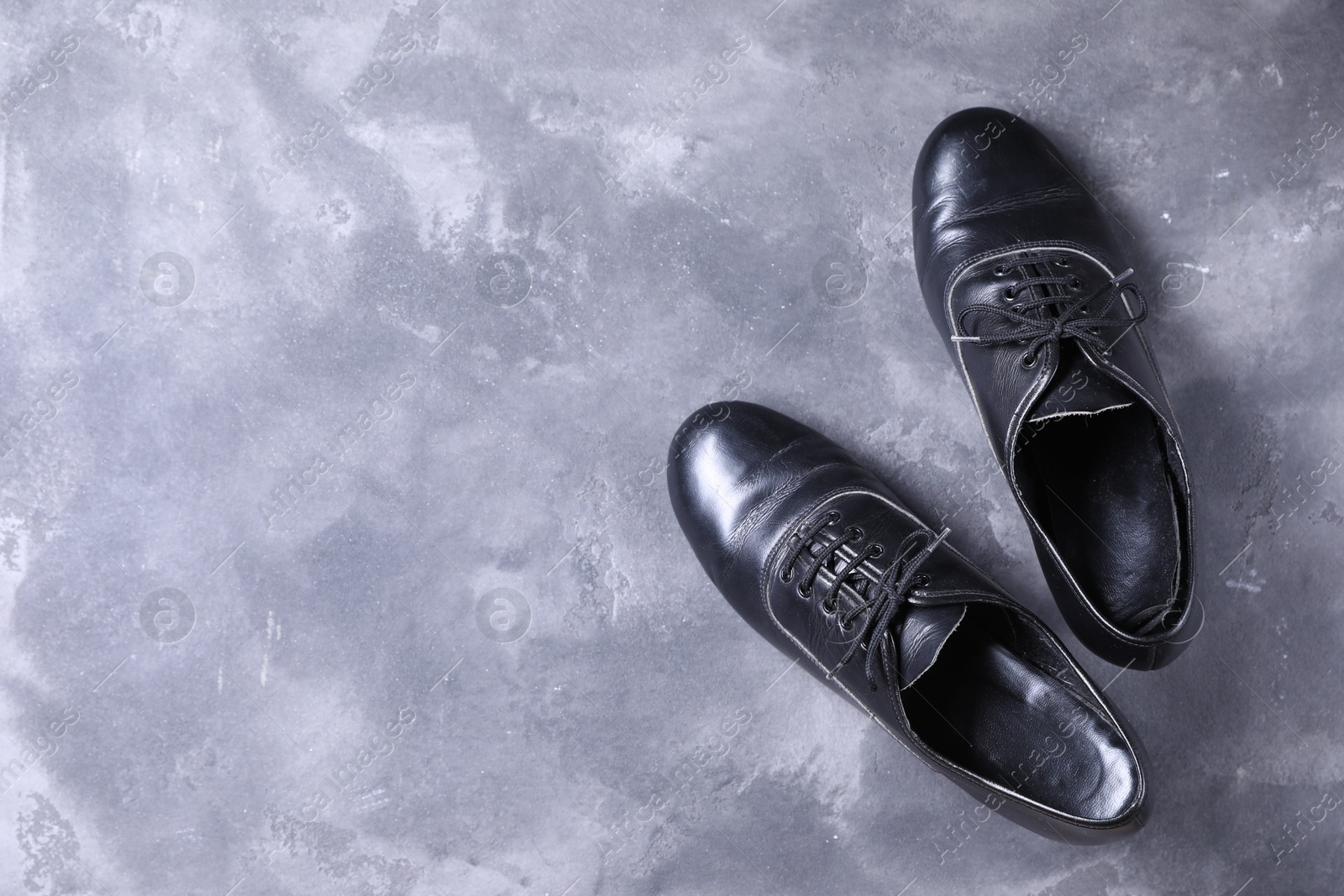 Photo of Pair of shoes for tap dance on grey surface, top view. Space for text