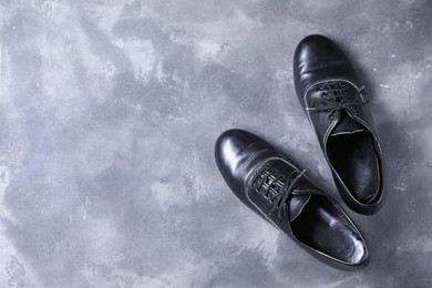 Photo of Pair of shoes for tap dance on grey surface, top view. Space for text