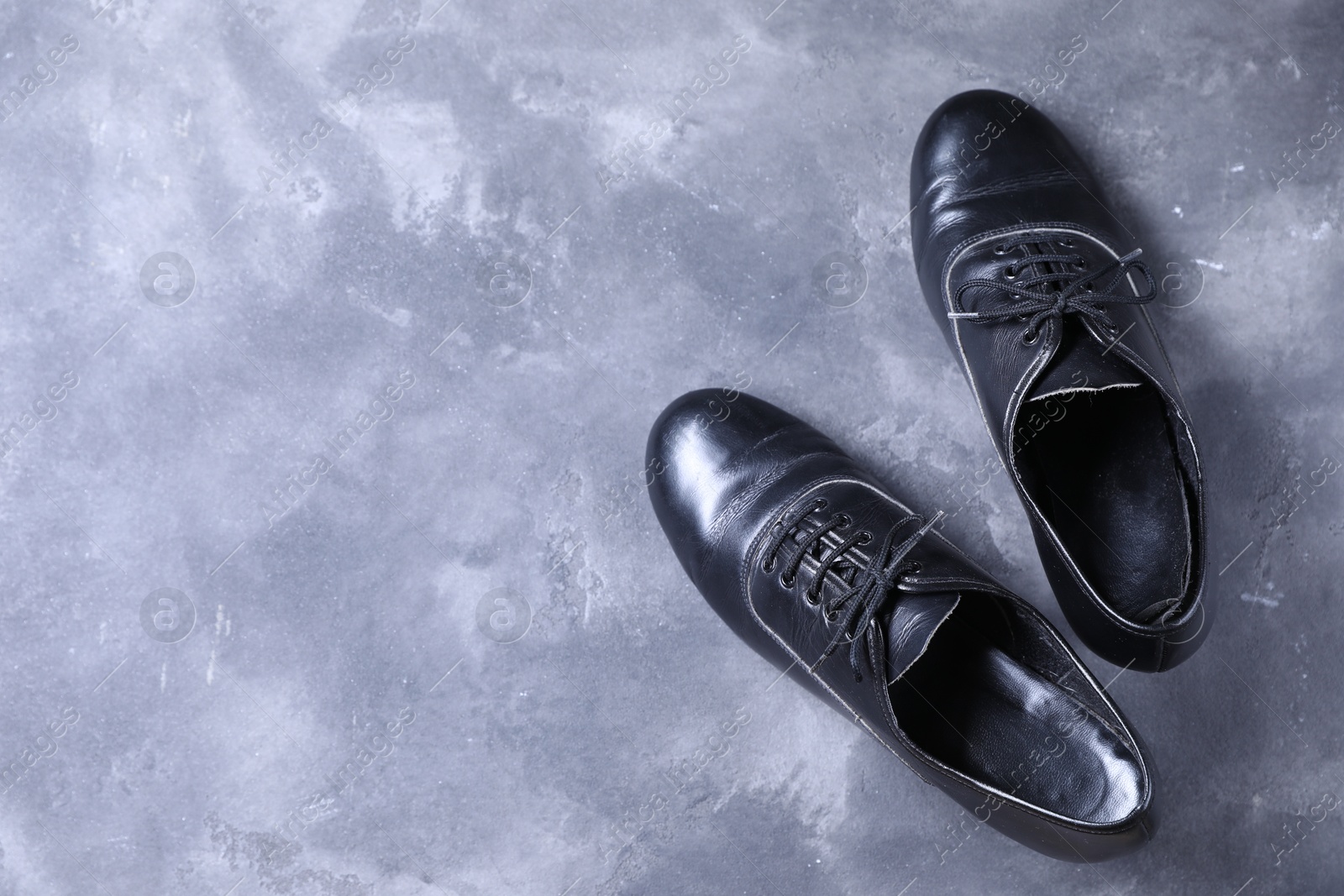 Photo of Pair of shoes for tap dance on grey surface, top view. Space for text