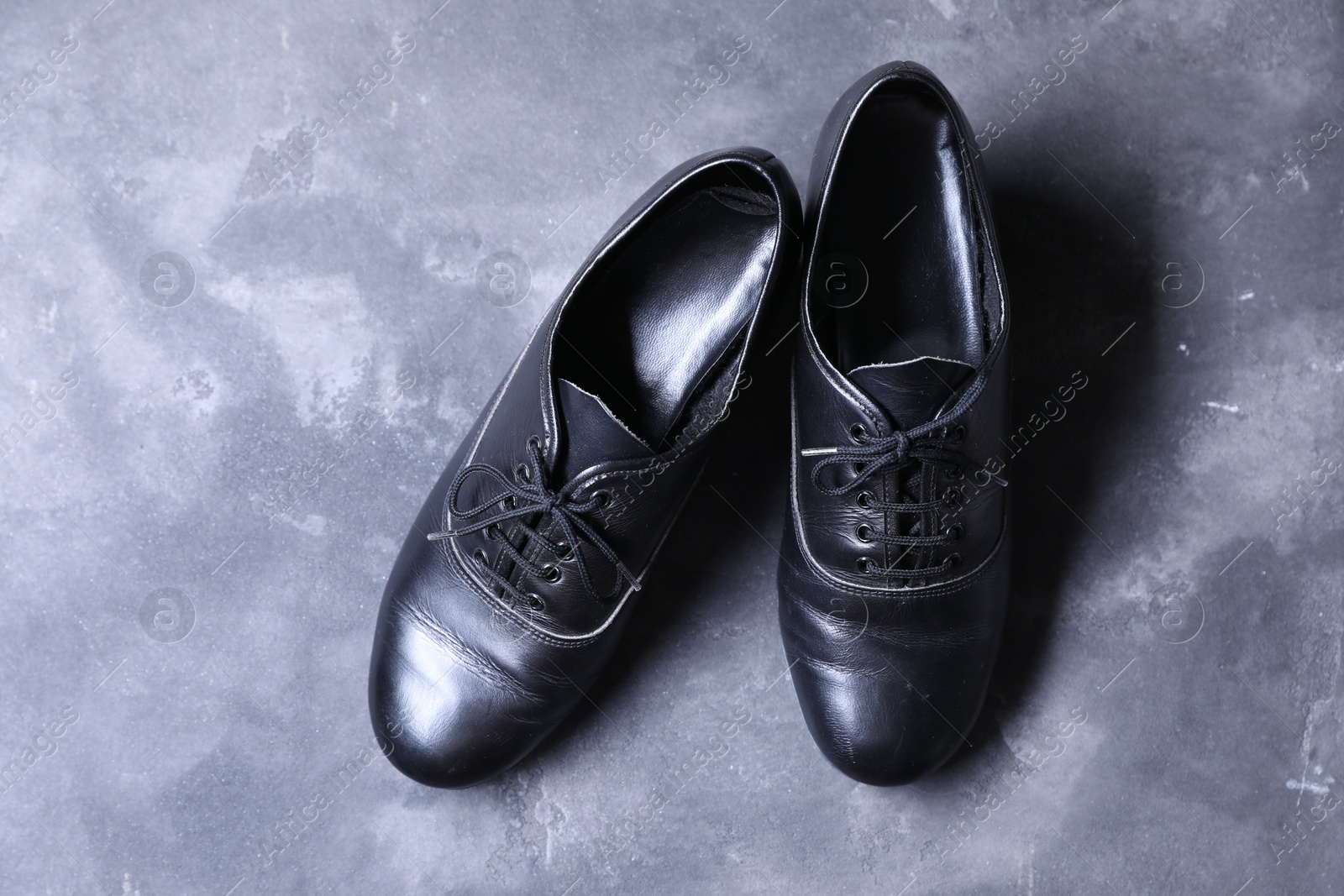 Photo of Pair of tap shoes on grey surface, top view. Tap dance