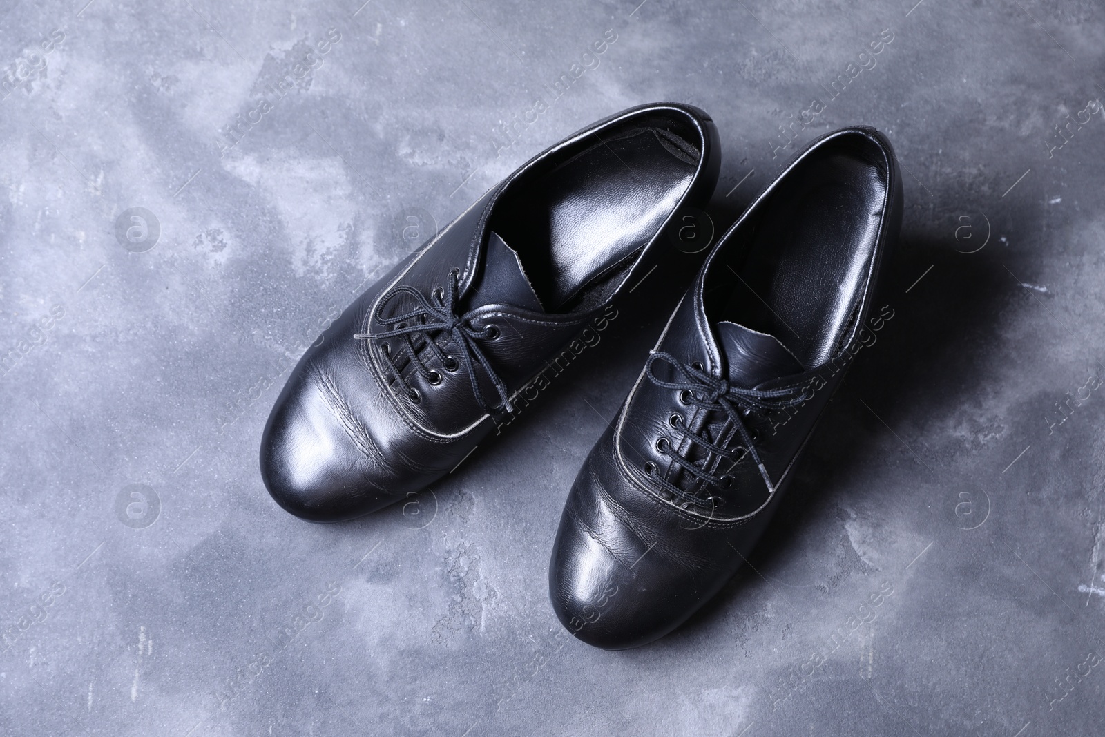 Photo of Pair of tap shoes on grey surface, top view. Tap dance