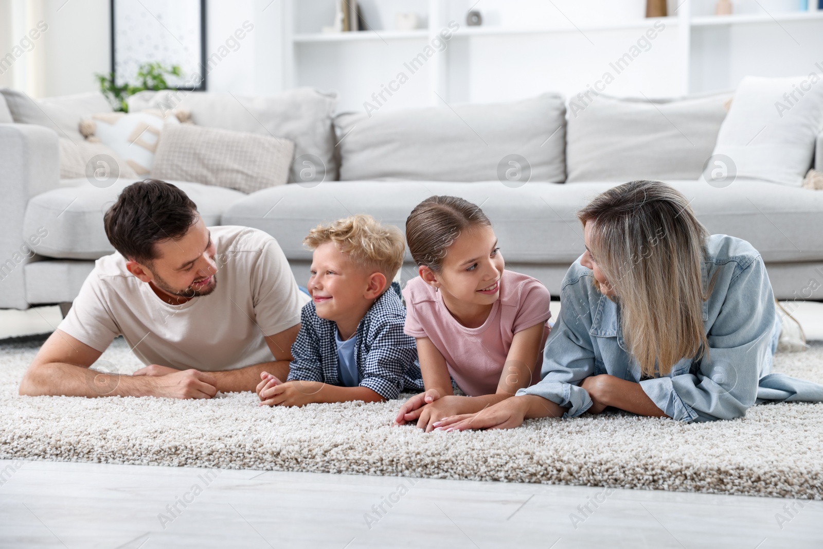 Photo of Happy family lying on floor at home