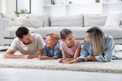 Photo of Happy family lying on floor at home