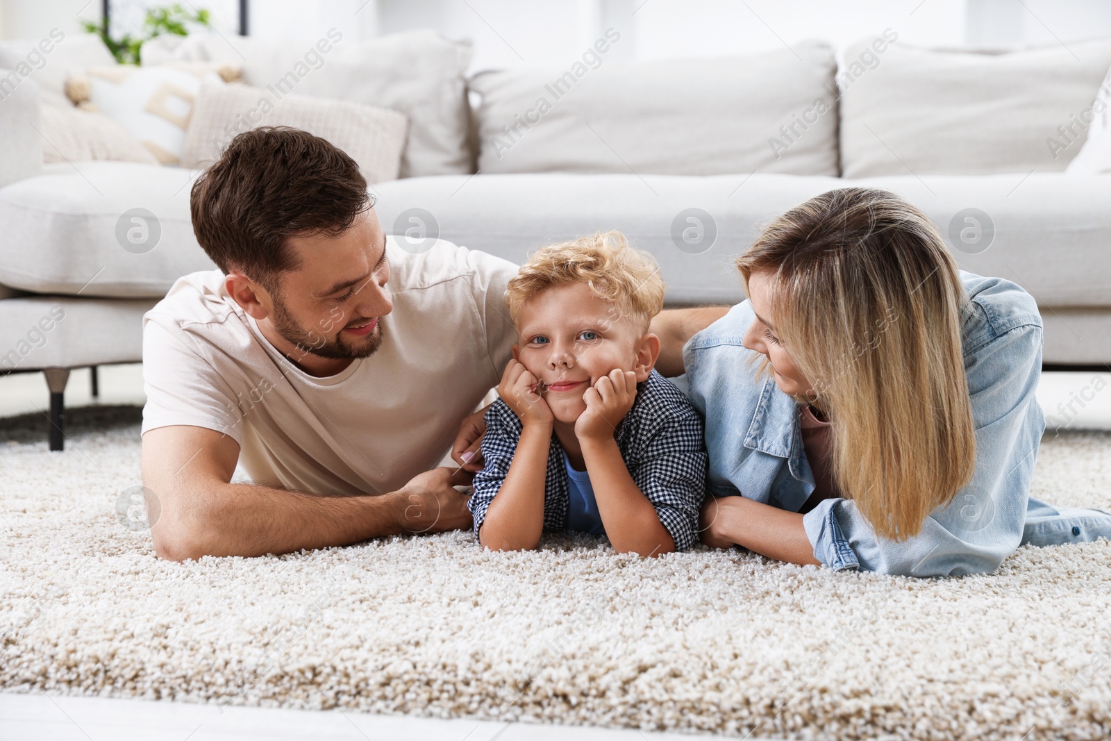 Photo of Happy family lying on floor at home