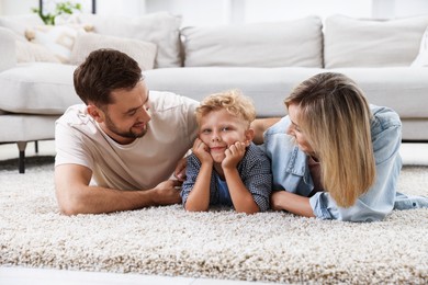 Photo of Happy family lying on floor at home