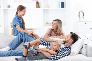 Photo of Happy family spending time together on sofa at home