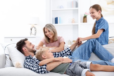 Photo of Happy family spending time together on sofa at home