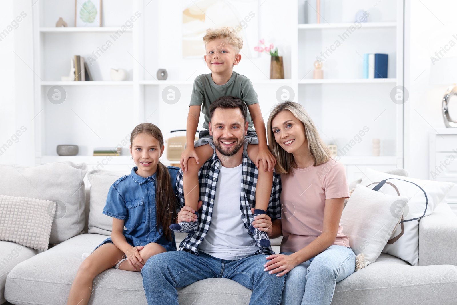 Photo of Happy family sitting on sofa at home