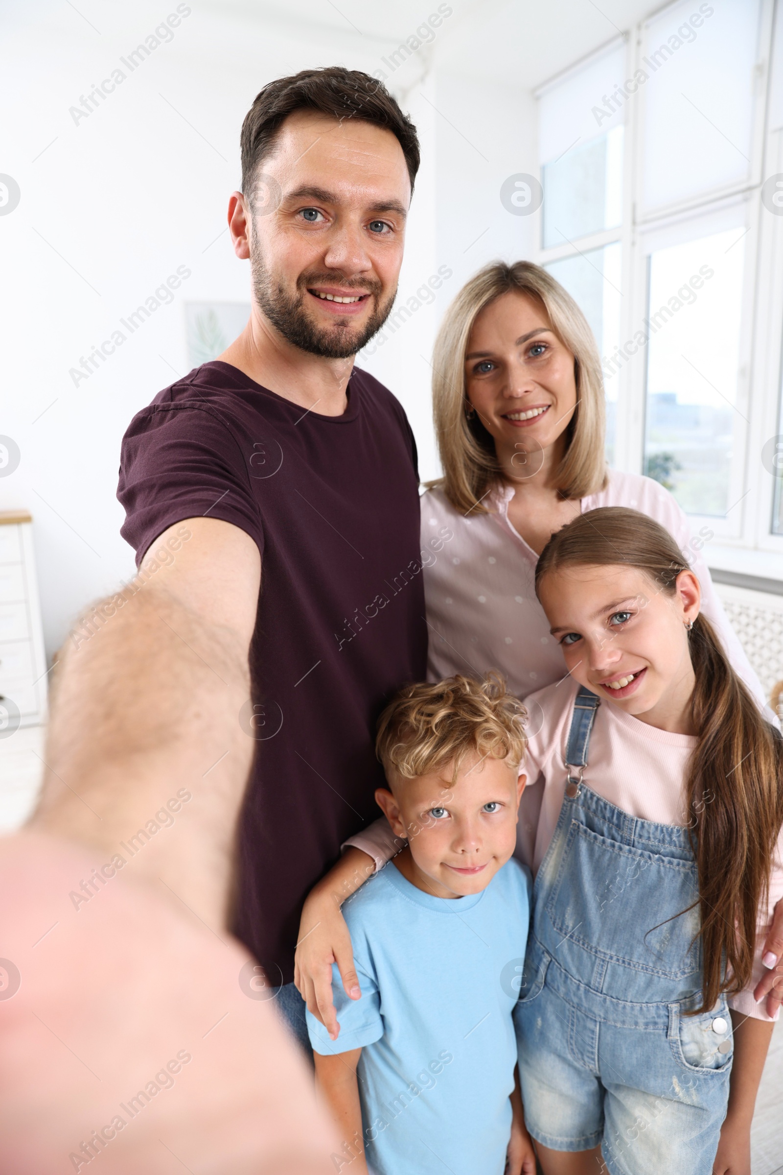 Photo of Happy family taking selfie in light room