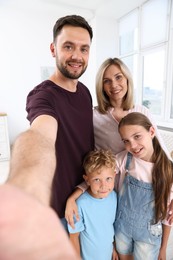 Photo of Happy family taking selfie in light room