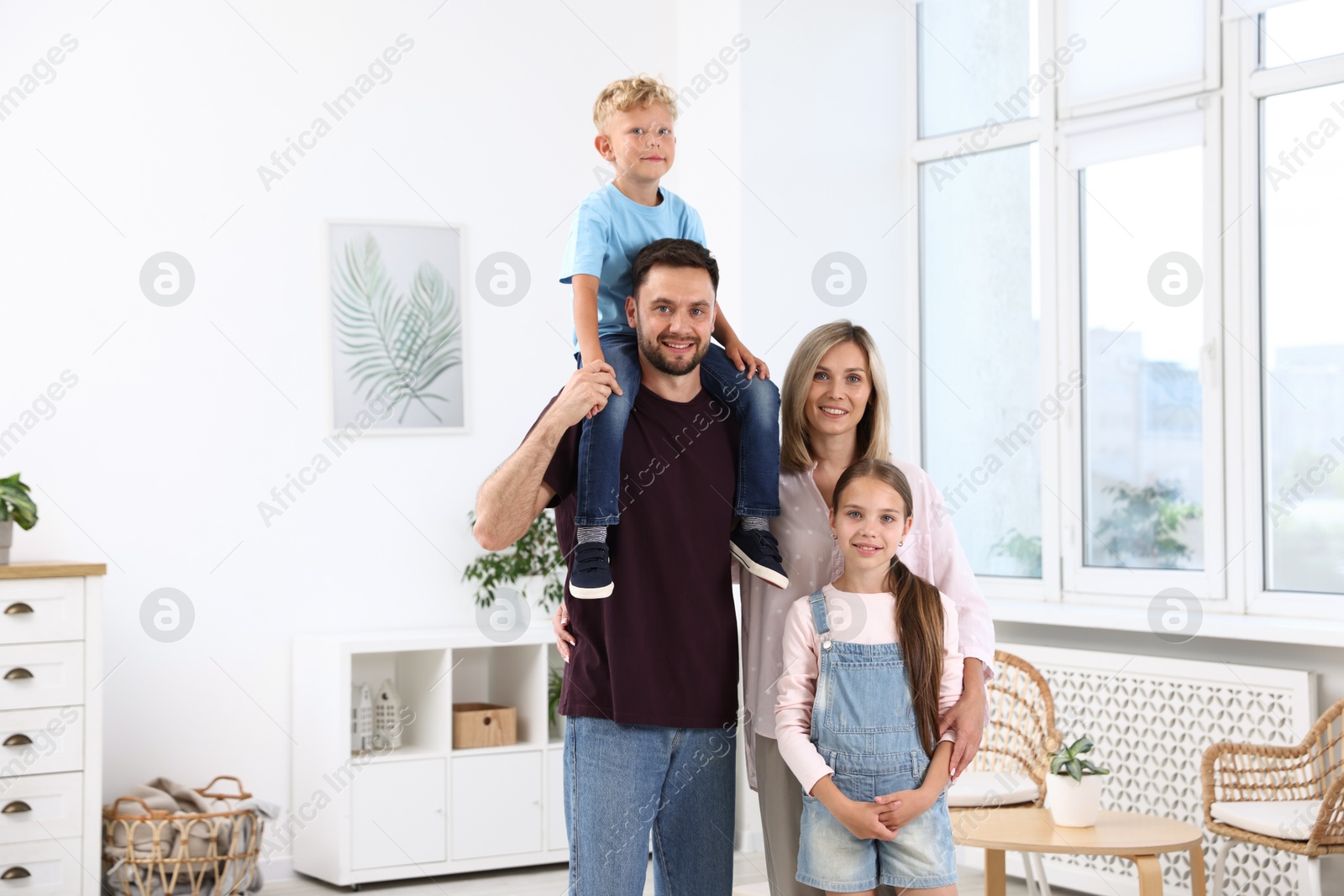 Photo of Family portrait of happy parents and their children in light room