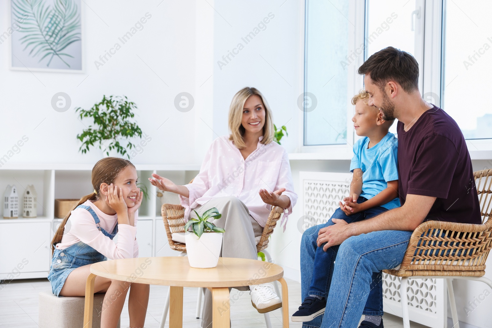 Photo of Happy family spending time together near coffee table at home