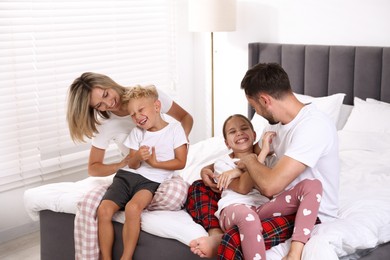 Photo of Happy family having fun on bed at home