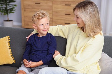 Photo of Happy mother and her son on sofa at home. Family