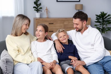 Photo of Happy family sitting on sofa at home