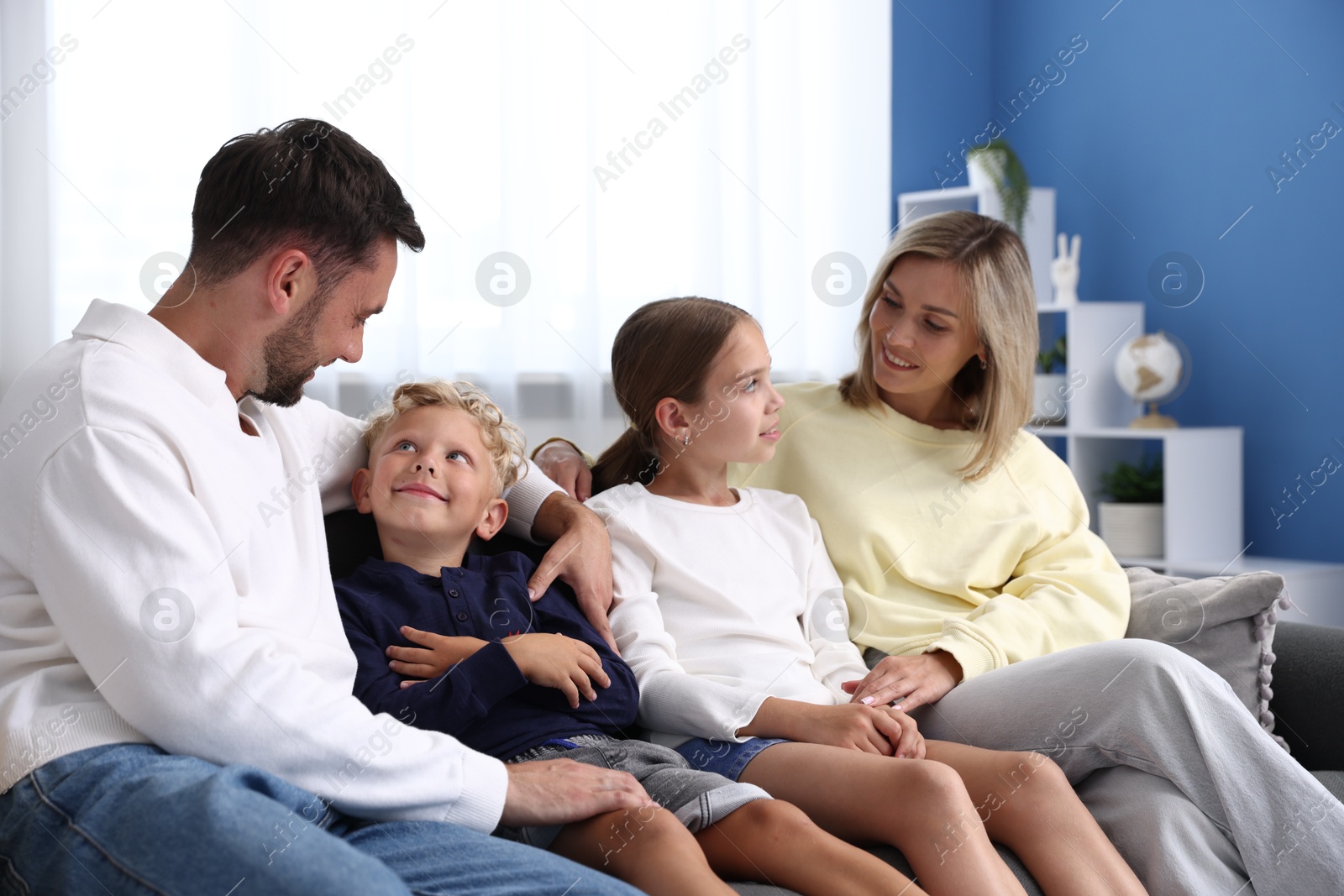 Photo of Happy family sitting on sofa at home