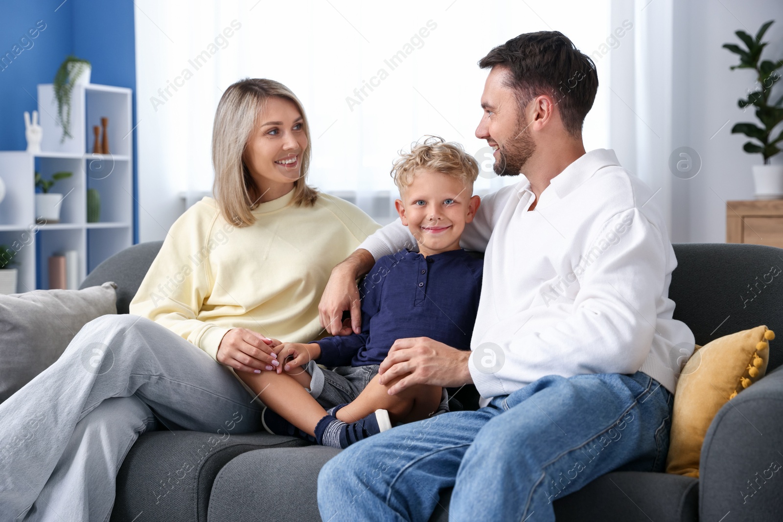 Photo of Happy family sitting on sofa at home