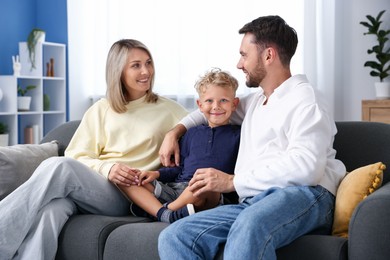 Photo of Happy family sitting on sofa at home