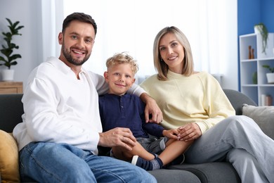 Photo of Happy family sitting on sofa at home