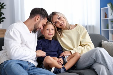 Photo of Happy family sitting on sofa at home