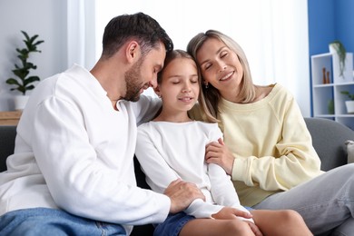Photo of Happy family sitting on sofa at home