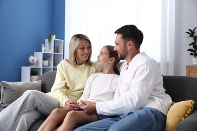 Photo of Happy family sitting on sofa at home