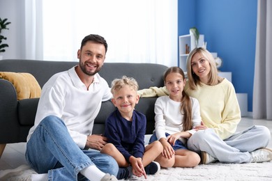 Photo of Happy family sitting on floor at home