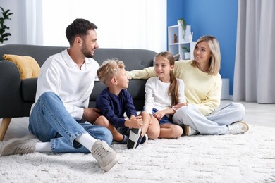 Photo of Happy family sitting on floor at home