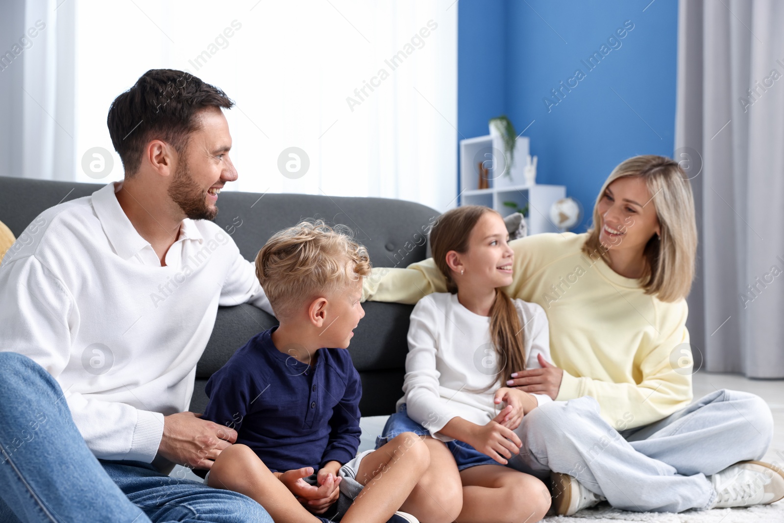 Photo of Happy family sitting on floor at home