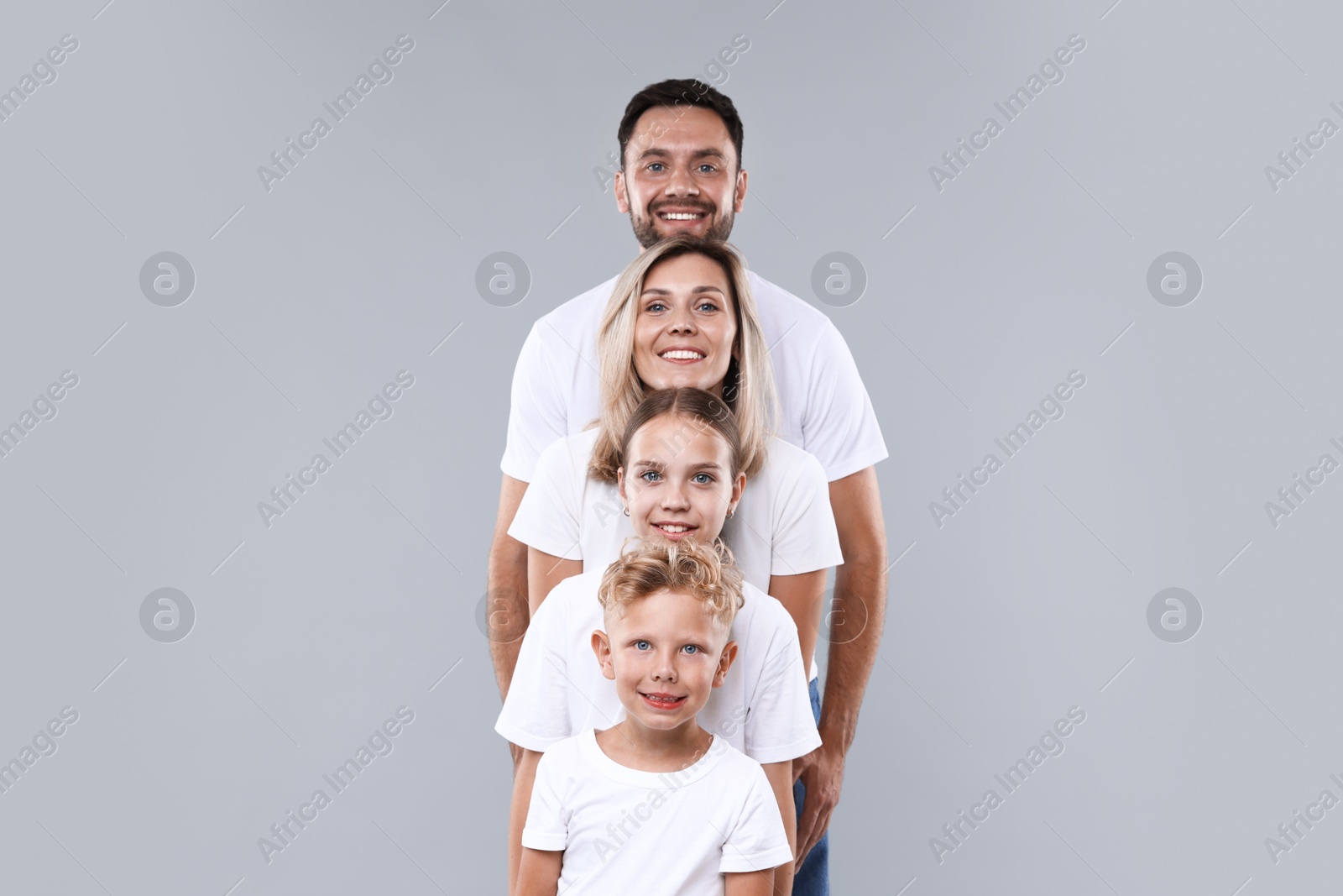Photo of Family portrait of happy parents and their children on grey background