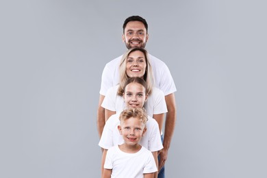 Photo of Family portrait of happy parents and their children on grey background