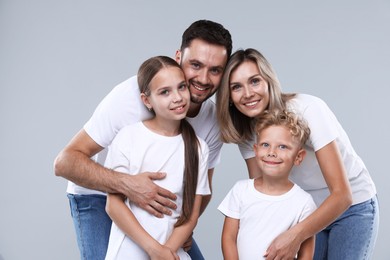 Photo of Family portrait of happy parents and their children on grey background