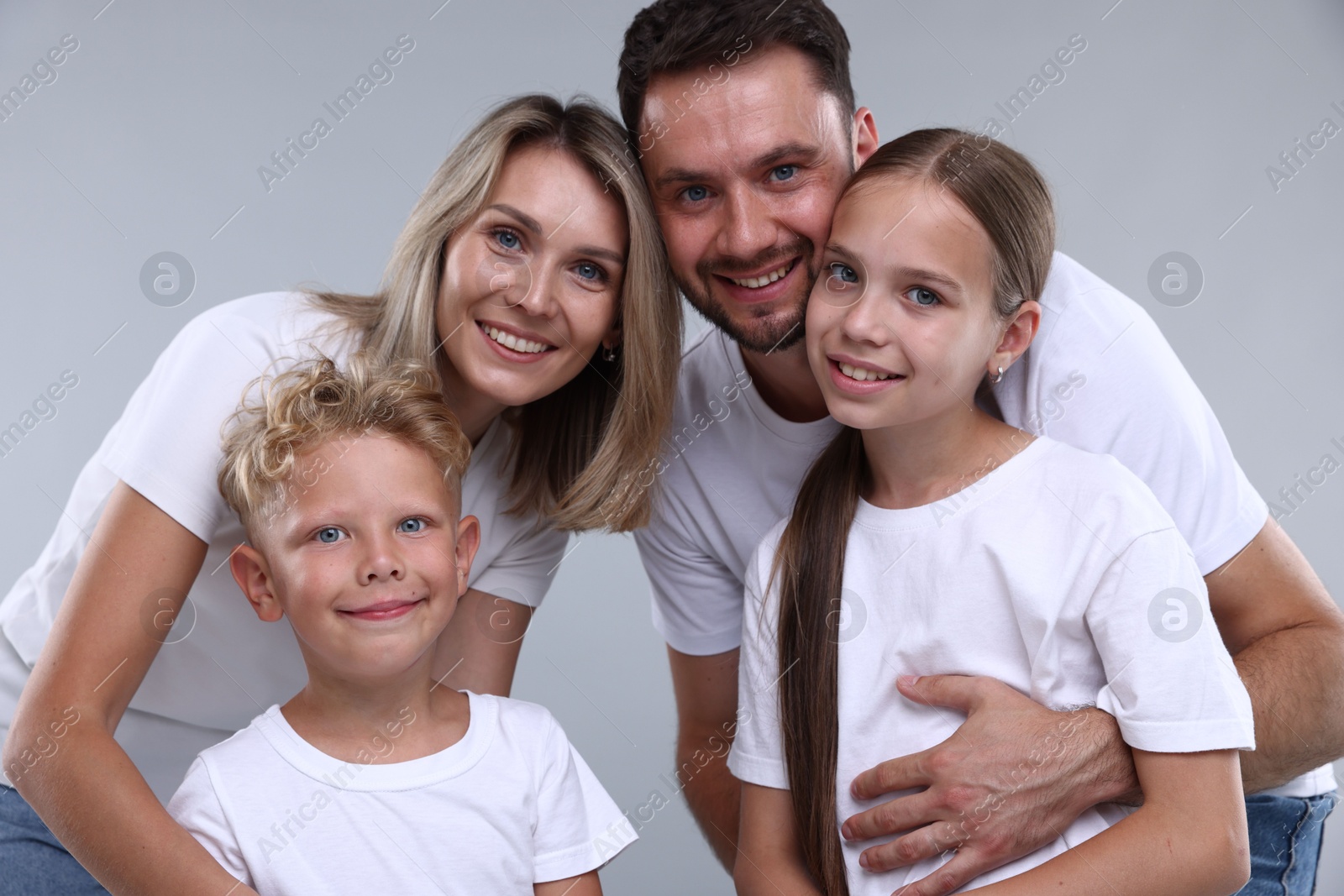Photo of Family portrait of happy parents and their children on grey background