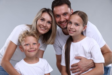 Photo of Family portrait of happy parents and their children on grey background