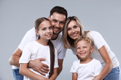 Photo of Family portrait of happy parents and their children on grey background