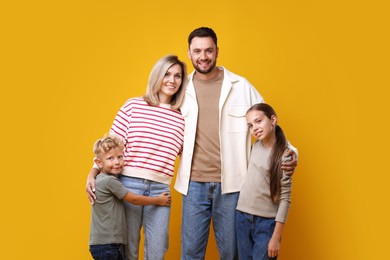 Photo of Family portrait of happy parents and their children on yellow background