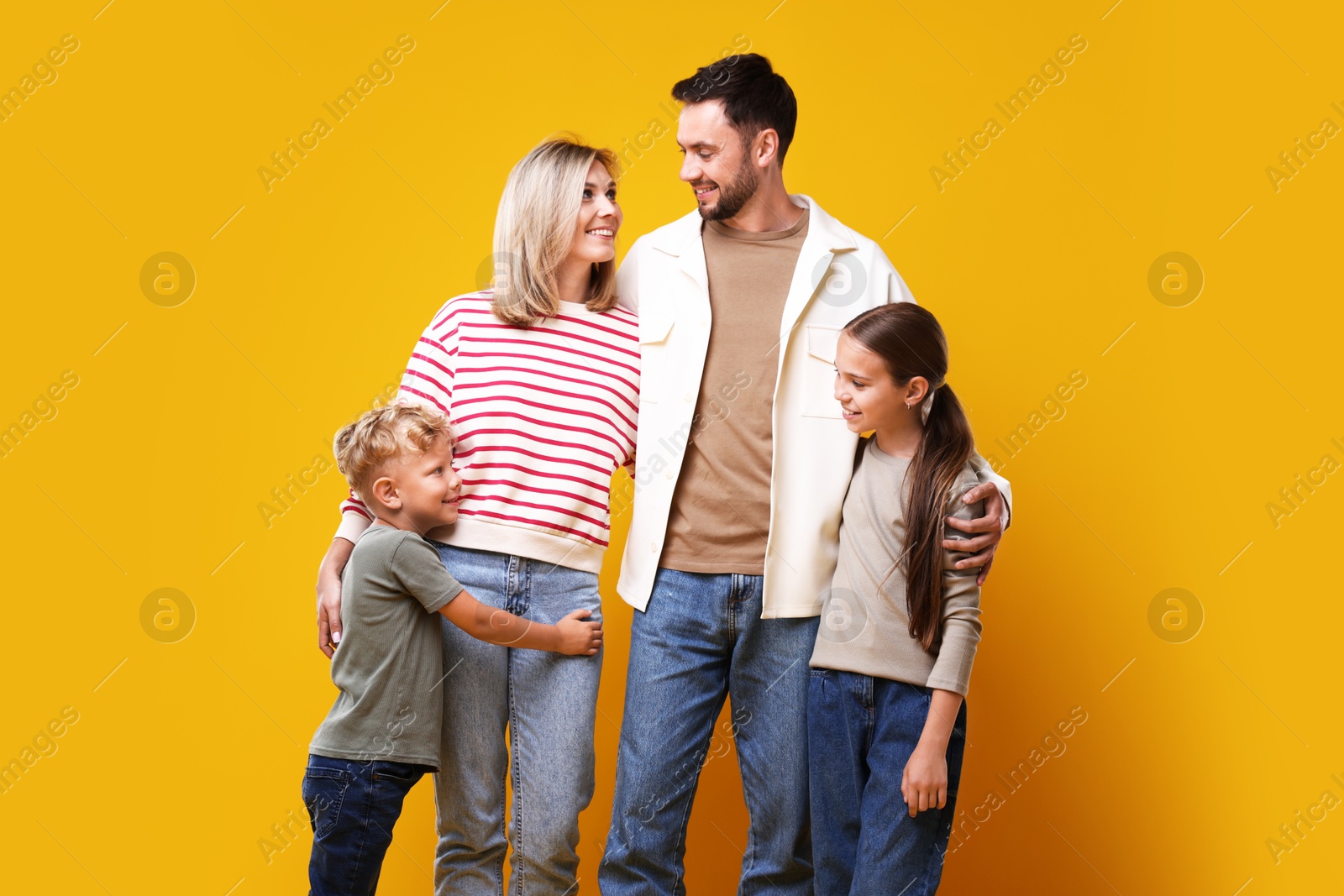 Photo of Family portrait of happy parents and their children on yellow background