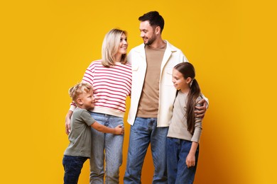 Photo of Family portrait of happy parents and their children on yellow background