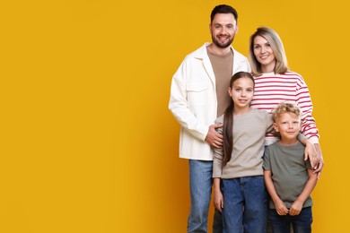 Photo of Family portrait of happy parents and their children on yellow background. Space for text