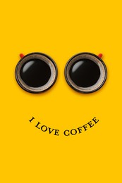 Image of I love coffee poster with happy face. Phrase as smile and coffee in cups as eyes on orange background, top view